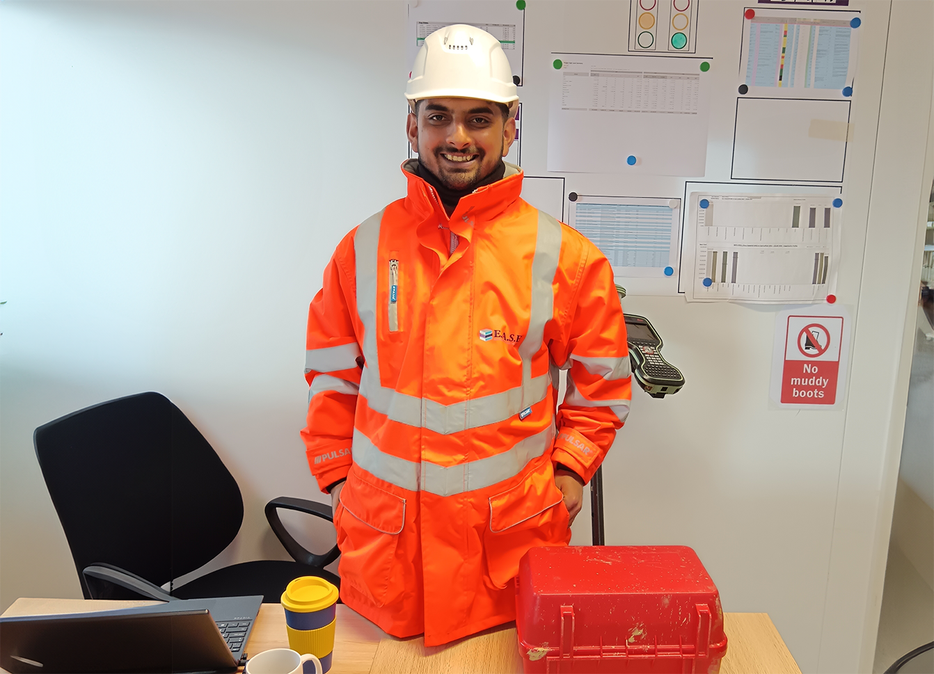 Smiling man in orange high vis jacket and white hard hat