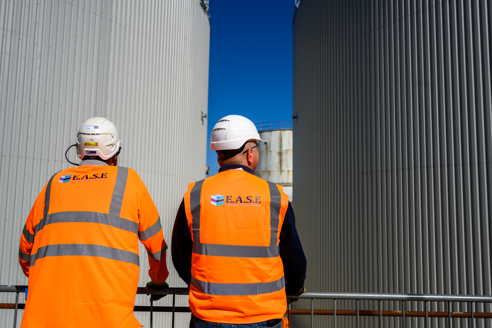 Two site engineers at Whitlingham STC between storage tanks